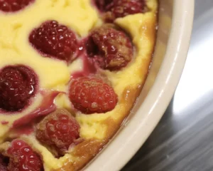 Clafoutis aux framboises servie avec du sucre glace